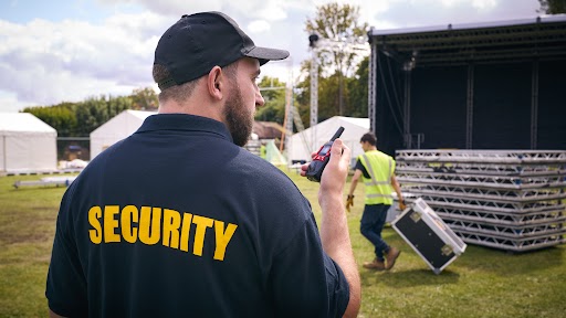 a security man with black hat holding a walkie talkie